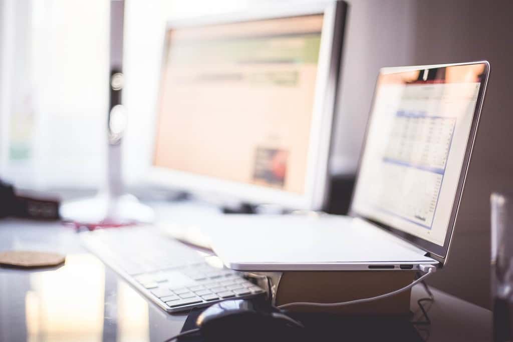 Photo of an expensive office desk with desktop and laptop. Artivle highlighting the use of social media to enhance your career