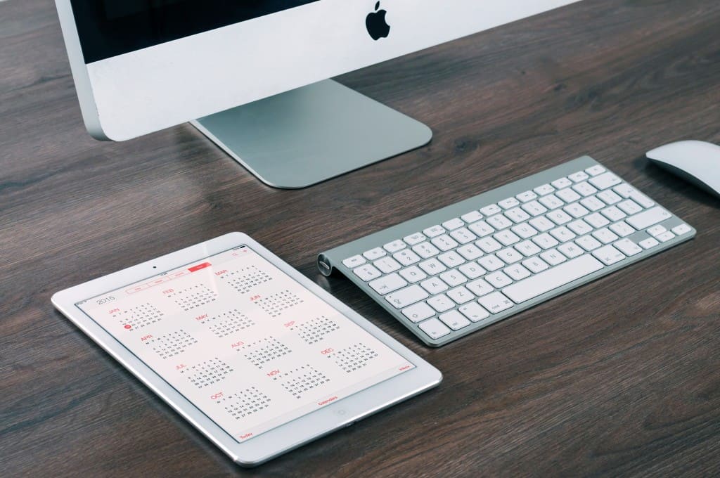 Photo of a keypay, ipad open to a calender on a desk. Illustrating recruiters using social media article